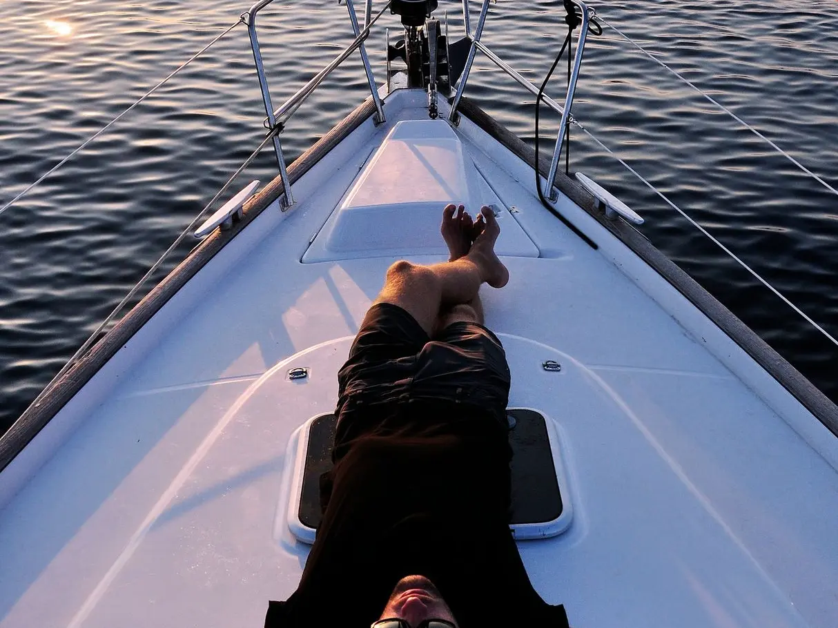 man lying on white boat